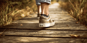 close up of the back of a person's shoe walking down a path