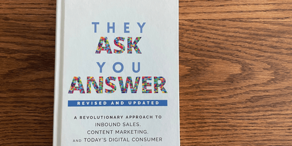 cover of They Ask, You Answer book on wood background