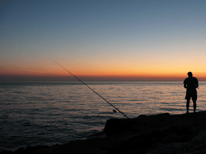 Person fishing at sunrise