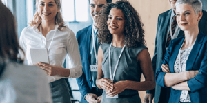 a group of association members at a conference smiling at a person talking